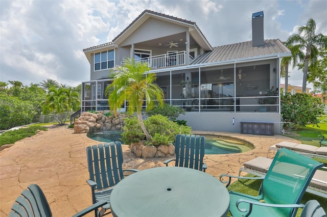 view of patio / terrace with a sunroom, a ceiling fan, a balcony, and outdoor dining area