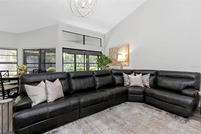 living room with a chandelier, high vaulted ceiling, and wood finished floors