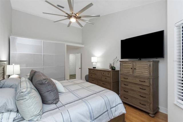 bedroom featuring light wood finished floors, vaulted ceiling, and ceiling fan