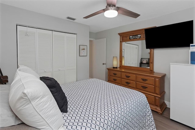 bedroom with a closet, wood finished floors, and ceiling fan