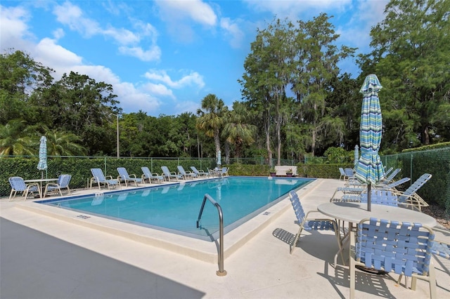 community pool featuring fence and a patio
