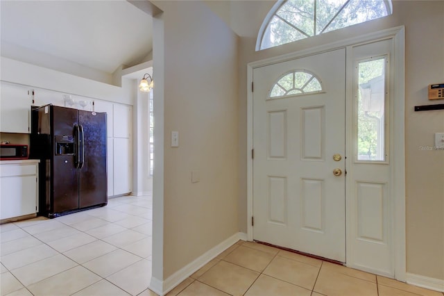 8110 Pond Shadow Ln, Tampa, FL 33635 - entryway featuring vaulted ceiling, light tile patterned floors, and baseboards