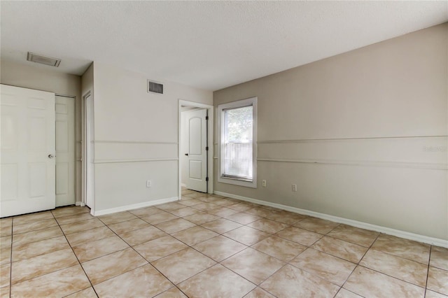 8110 Pond Shadow Ln, Tampa, FL 33635 - unfurnished bedroom with light tile patterned flooring, baseboards, a closet, and a textured ceiling