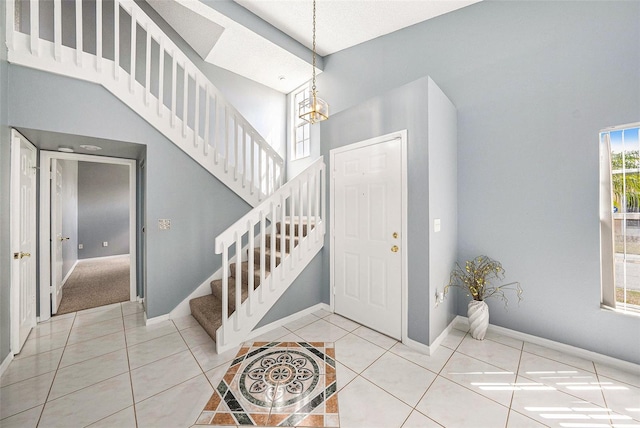 4270 Boston Cir, New Port Richey, FL 34653 - tiled foyer entrance featuring stairway, baseboards, a chandelier, and a high ceiling