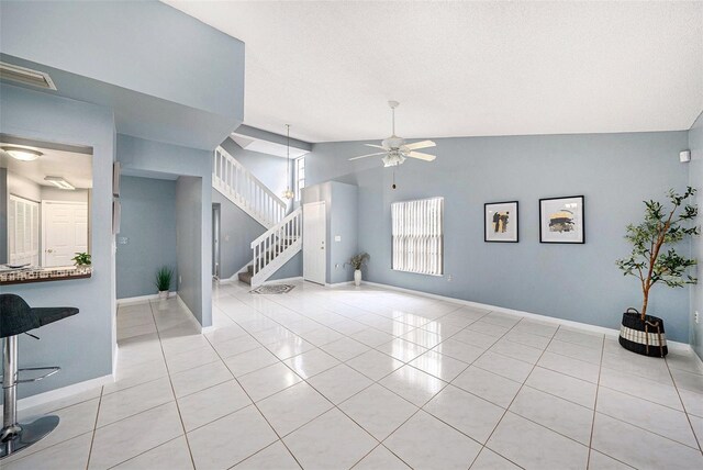 4270 Boston Cir, New Port Richey, FL 34653 - unfurnished living room with ceiling fan, stairs, light tile patterned floors, baseboards, and vaulted ceiling