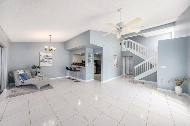4270 Boston Cir, New Port Richey, FL 34653 - living area featuring vaulted ceiling, stairway, tile patterned flooring, a ceiling fan, and a chandelier
