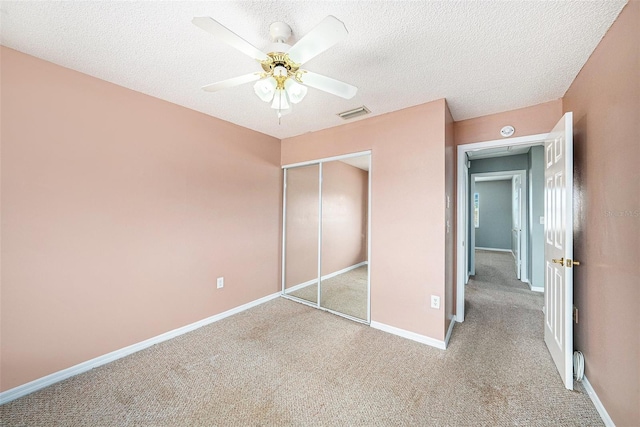 4270 Boston Cir, New Port Richey, FL 34653 - unfurnished bedroom with carpet, a closet, a textured ceiling, baseboards, and a ceiling fan