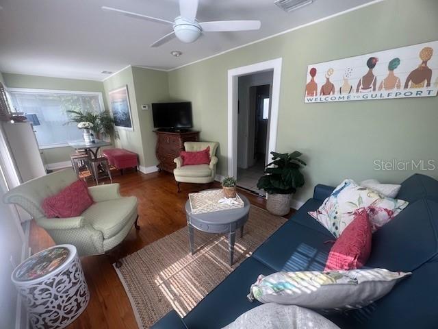 3031 56th St S, Gulfport, FL 33707 - living area with wood finished floors, a ceiling fan, and baseboards