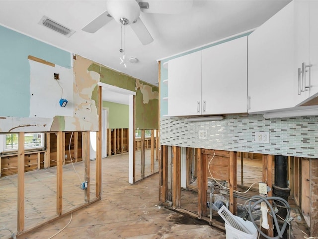 3031 56th St S, Gulfport, FL 33707 - kitchen with a ceiling fan, white cabinetry, and tasteful backsplash