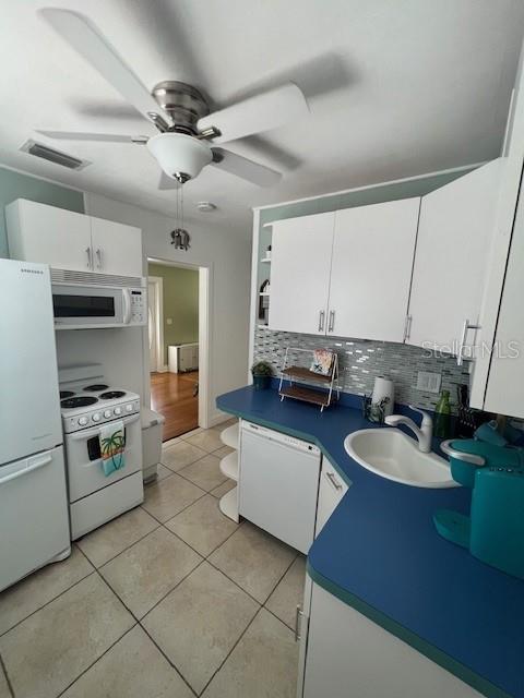 3031 56th St S, Gulfport, FL 33707 - kitchen with white appliances, a sink, open shelves, white cabinets, and backsplash