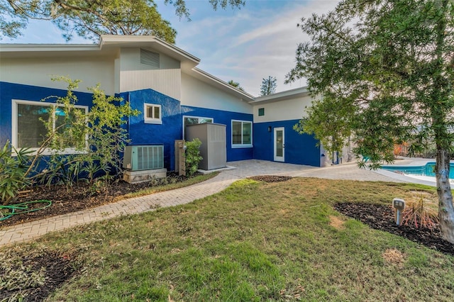 330 Pineapple St, Tarpon Springs, FL 34689 - rear view of house with stucco siding, a patio, a yard, an outdoor pool, and central AC