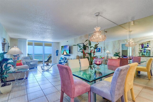 2504 Gulf Blvd Unit 201, Indian Rocks Beach, FL 33785 - tiled dining area featuring a chandelier, a textured ceiling, and a wall of windows