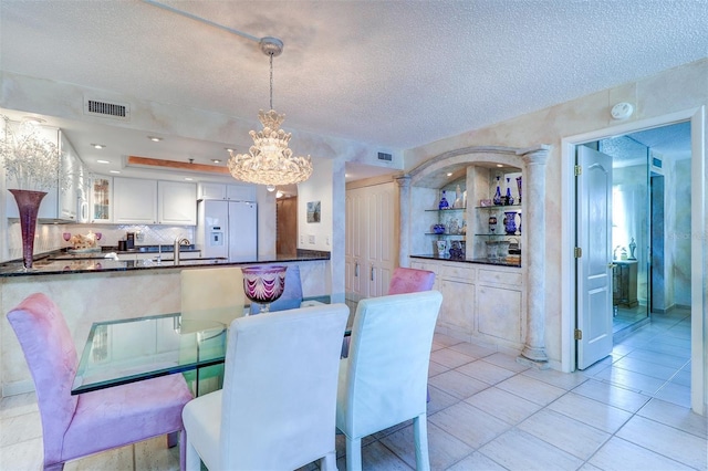 2504 Gulf Blvd Unit 201, Indian Rocks Beach, FL 33785 - dining space featuring a chandelier, a textured ceiling, and light tile patterned floors