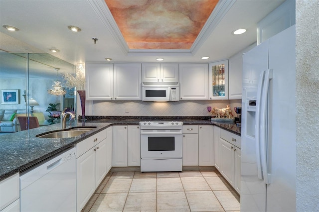 2504 Gulf Blvd Unit 201, Indian Rocks Beach, FL 33785 - kitchen with white appliances, a sink, a tray ceiling, tasteful backsplash, and white cabinets