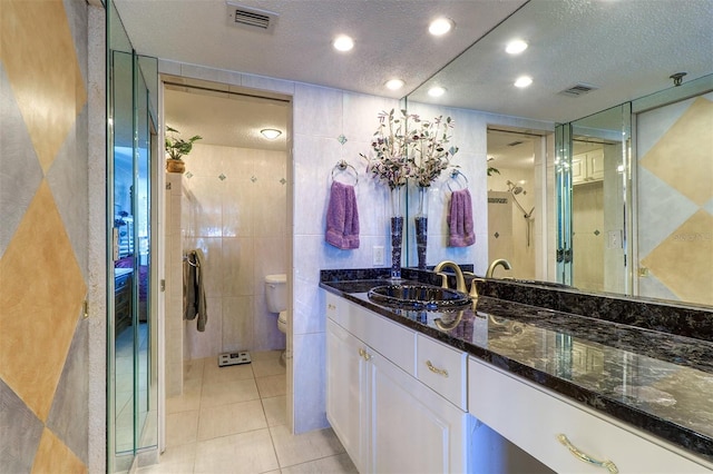 2504 Gulf Blvd Unit 201, Indian Rocks Beach, FL 33785 - bathroom featuring toilet, a textured ceiling, tile patterned flooring, a tile shower, and vanity