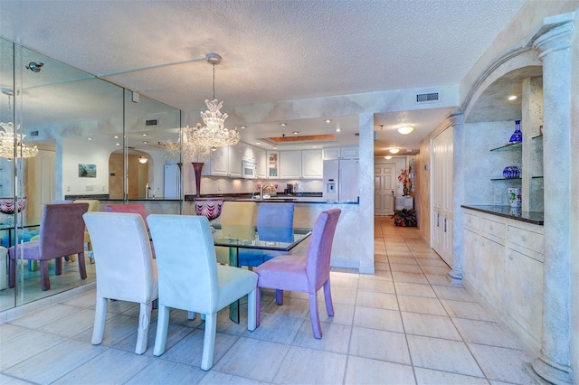 2504 Gulf Blvd Unit 201, Indian Rocks Beach, FL 33785 - dining room featuring a chandelier, a textured ceiling, and light tile patterned flooring