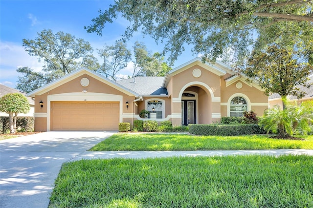view of front facade with stucco siding, an attached garage, driveway, and a front lawn