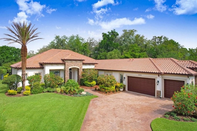 14910 Tom Fazio Ct, Tampa, FL 33626 - mediterranean / spanish-style home with stucco siding, a garage, stone siding, and a front yard