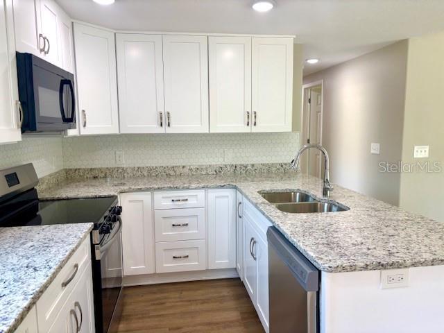 6952 W Barbara Ann Ln, Homosassa, FL 34446 - kitchen with stainless steel appliances, a sink, a peninsula, white cabinets, and recessed lighting