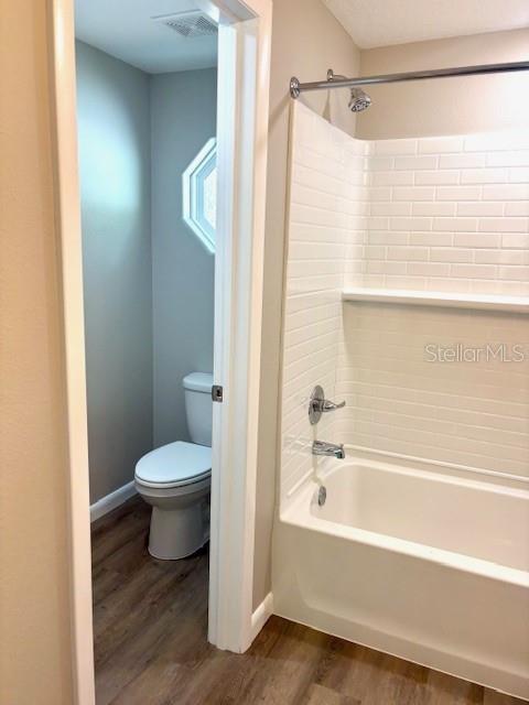 6952 W Barbara Ann Ln, Homosassa, FL 34446 - bathroom with wood finished floors, toilet, shower / tub combination, and baseboards