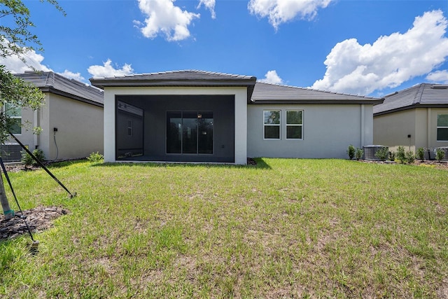 10098 Banyan Breeze Blvd, Land O Lakes, FL 34638 - back of house featuring stucco siding, a lawn, and a sunroom