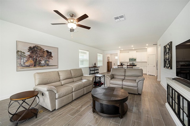 10098 Banyan Breeze Blvd, Land O Lakes, FL 34638 - living area with wood tiled floors, a ceiling fan, recessed lighting, and baseboards