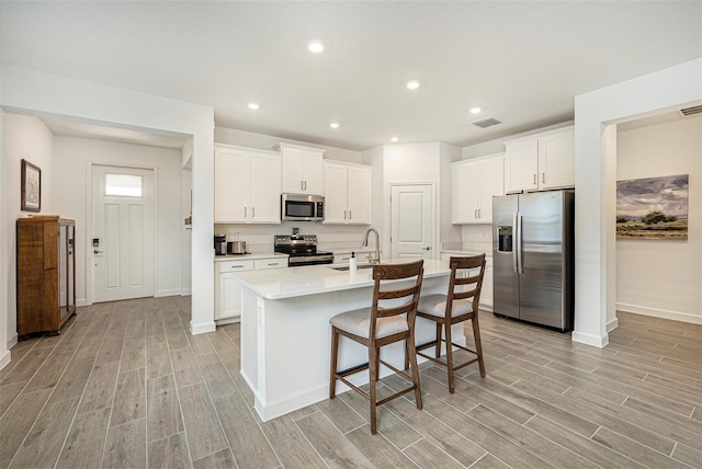 10098 Banyan Breeze Blvd, Land O Lakes, FL 34638 - kitchen featuring stainless steel appliances, a sink, light wood finished floors, light countertops, and recessed lighting