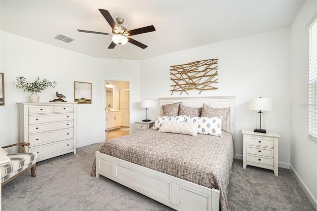 10098 Banyan Breeze Blvd, Land O Lakes, FL 34638 - bedroom with light carpet, baseboards, connected bathroom, and a ceiling fan