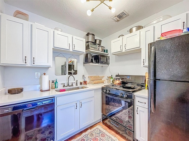 1221 E Hamilton Ave, Tampa, FL 33604 - kitchen featuring black appliances, a sink, light countertops, white cabinets, and a textured ceiling