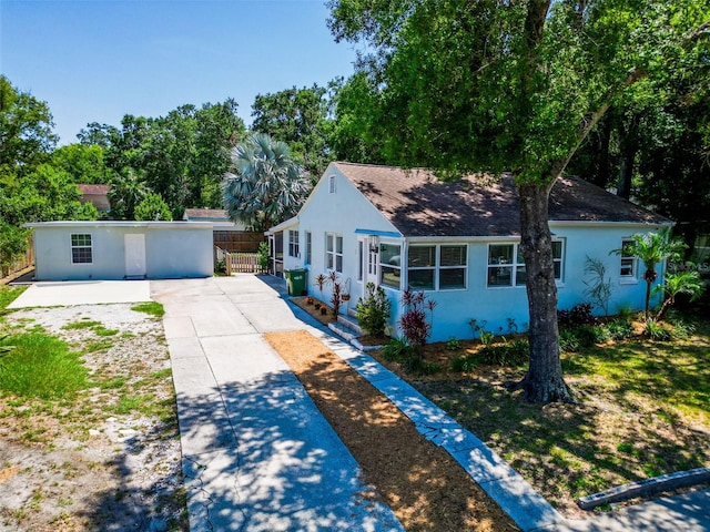 1221 E Hamilton Ave, Tampa, FL 33604 - view of front facade featuring stucco siding, concrete driveway, and roof with shingles