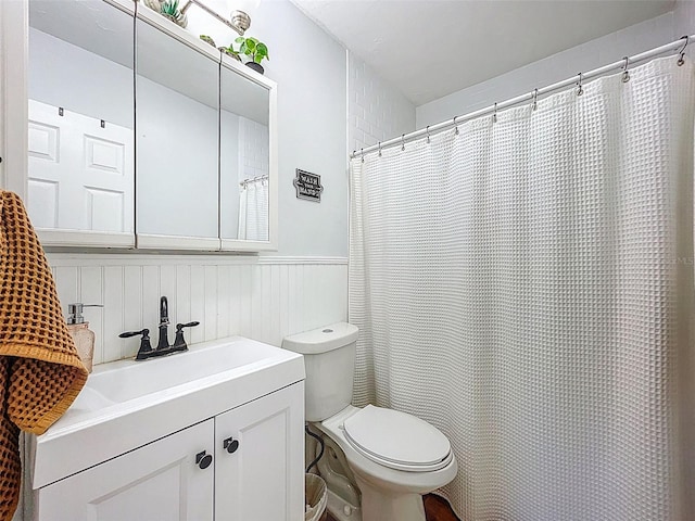 1221 E Hamilton Ave, Tampa, FL 33604 - bathroom featuring a wainscoted wall, toilet, and vanity
