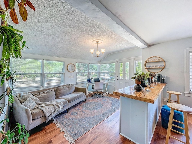 1221 E Hamilton Ave, Tampa, FL 33604 - living area featuring lofted ceiling, wood finished floors, a chandelier, and a textured ceiling