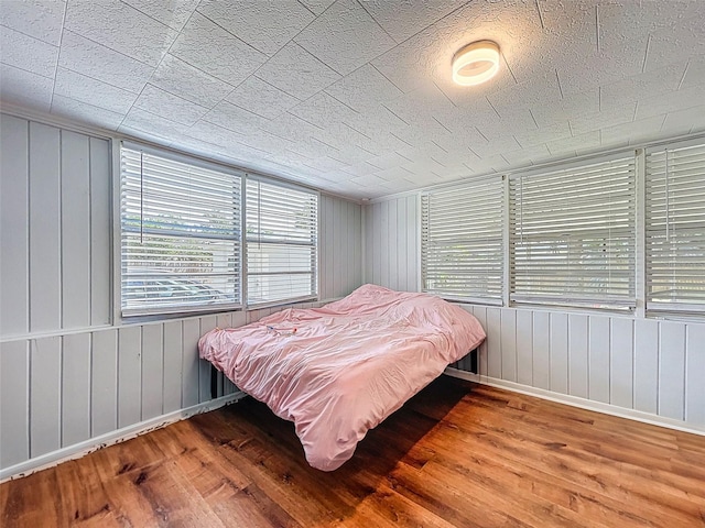 1221 E Hamilton Ave, Tampa, FL 33604 - bedroom featuring hardwood / wood-style flooring, baseboards, and wooden walls