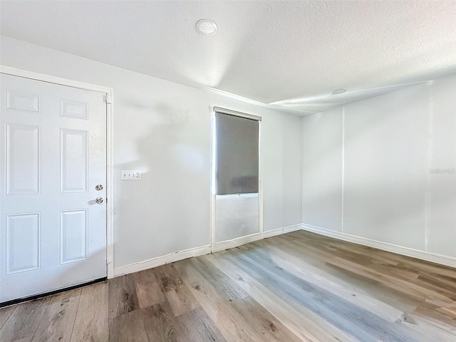 1221 E Hamilton Ave, Tampa, FL 33604 - spare room with wood finished floors, a textured ceiling, and baseboards