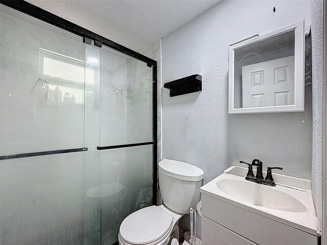 1221 E Hamilton Ave, Tampa, FL 33604 - bathroom with a textured wall, toilet, a shower stall, a textured ceiling, and vanity