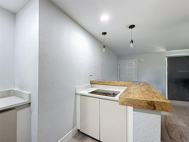 1221 E Hamilton Ave, Tampa, FL 33604 - kitchen with black electric stovetop, a textured wall, light wood finished floors, pendant lighting, and baseboards