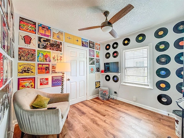 1221 E Hamilton Ave, Tampa, FL 33604 - sitting room featuring a ceiling fan, a textured ceiling, wood finished floors, and baseboards