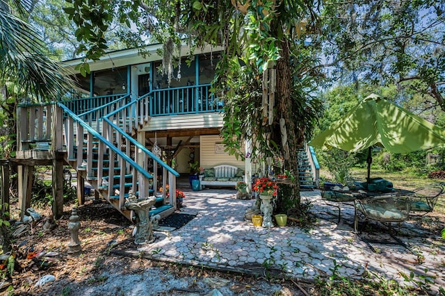 420 Hanby St, Crystal Beach, FL 34681 - rear view of house with stairway, a patio, and a sunroom