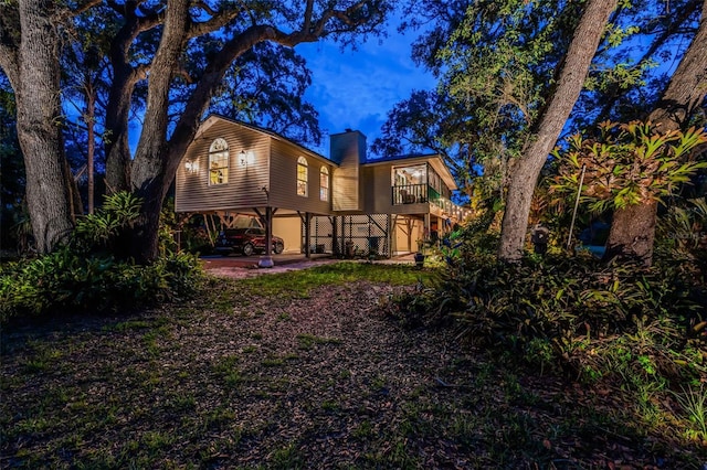420 Hanby St, Crystal Beach, FL 34681 - rear view of house featuring a chimney, a carport, and stairs
