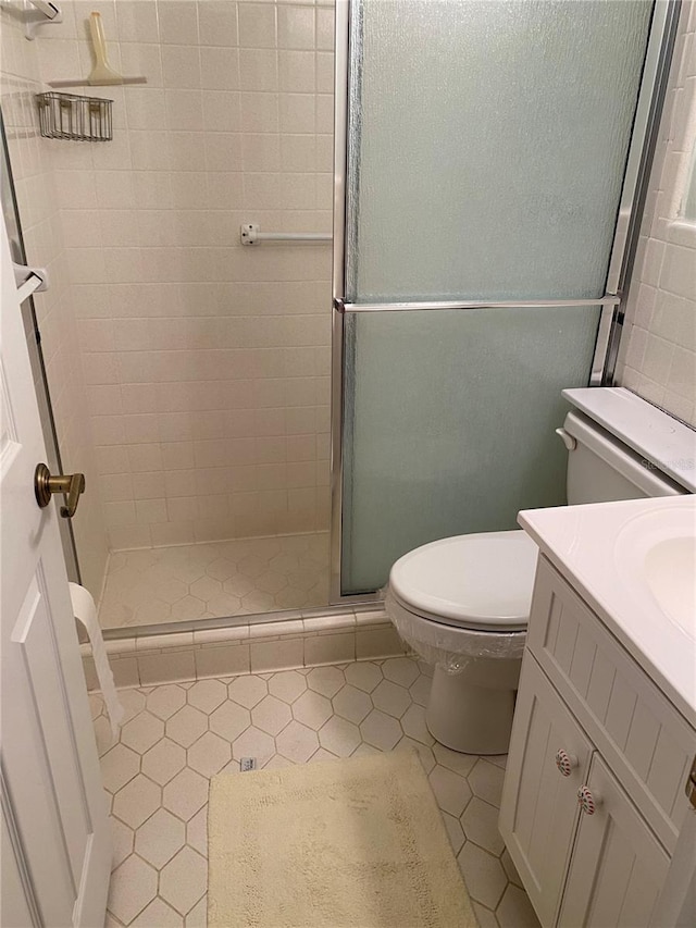 8055 112th St Unit 406, Seminole, FL 33772 - full bathroom featuring a stall shower, toilet, tile patterned floors, and vanity