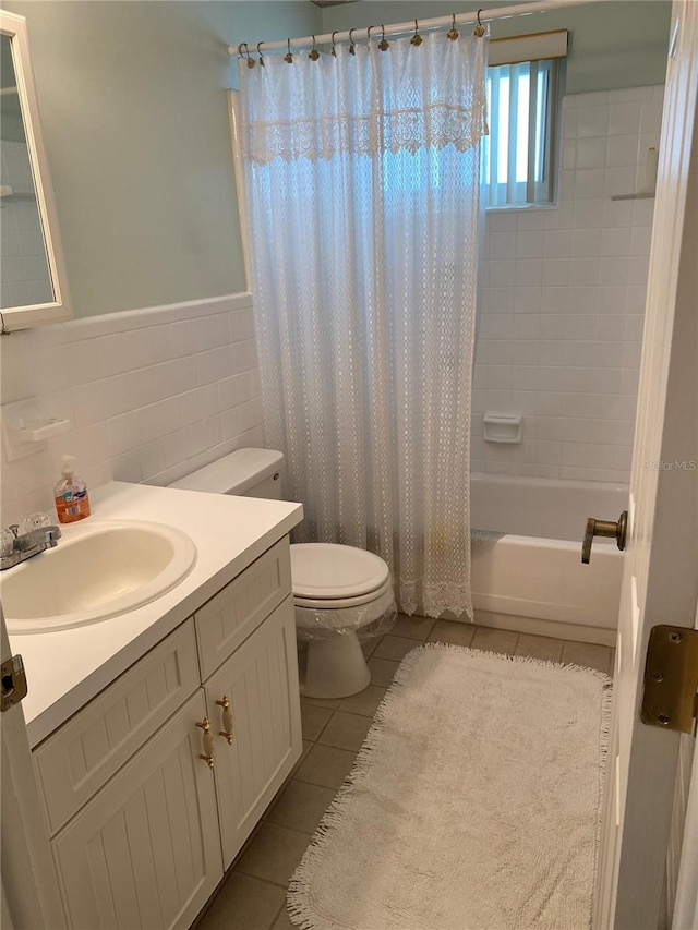 8055 112th St Unit 406, Seminole, FL 33772 - bathroom featuring toilet, tile patterned floors, vanity, shower / bathtub combination with curtain, and a wainscoted wall