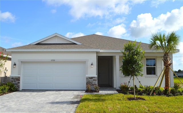 12320 49th St E, Parrish, FL 34219 - ranch-style house with decorative driveway, a garage, stone siding, and stucco siding