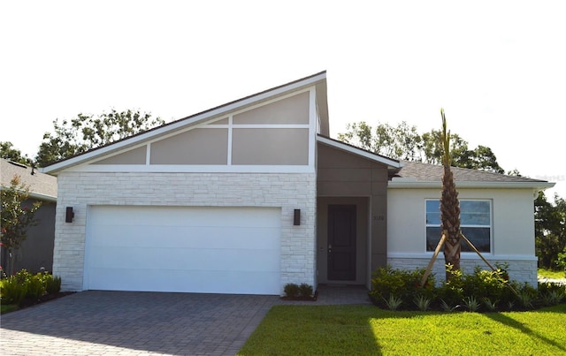 5120 125th Ave E, Parrish, FL 34219 - view of front of home featuring driveway, an attached garage, stucco siding, stone siding, and a front lawn