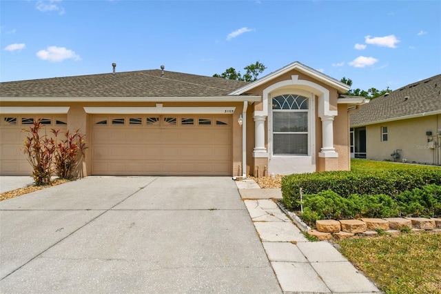 view of front facade featuring a garage, stucco siding, and driveway