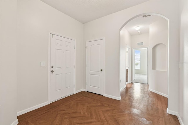 entryway with arched walkways and baseboards