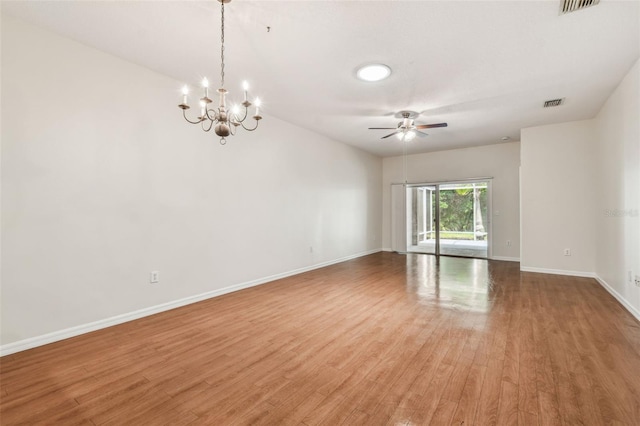 empty room featuring light wood finished floors, baseboards, a ceiling fan, and a chandelier