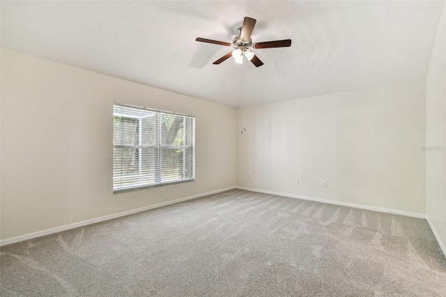 spare room with carpet, ceiling fan, and baseboards