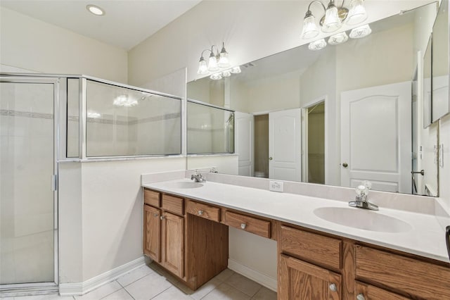full bathroom with a chandelier, a shower stall, tile patterned floors, double vanity, and baseboards