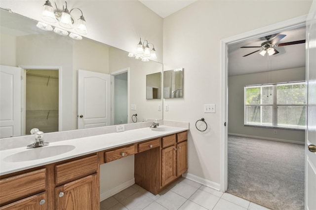 full bathroom featuring double vanity, tile patterned flooring, a ceiling fan, baseboards, and a chandelier