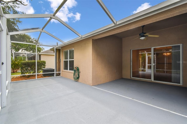view of patio / terrace with ceiling fan, central air condition unit, and glass enclosure